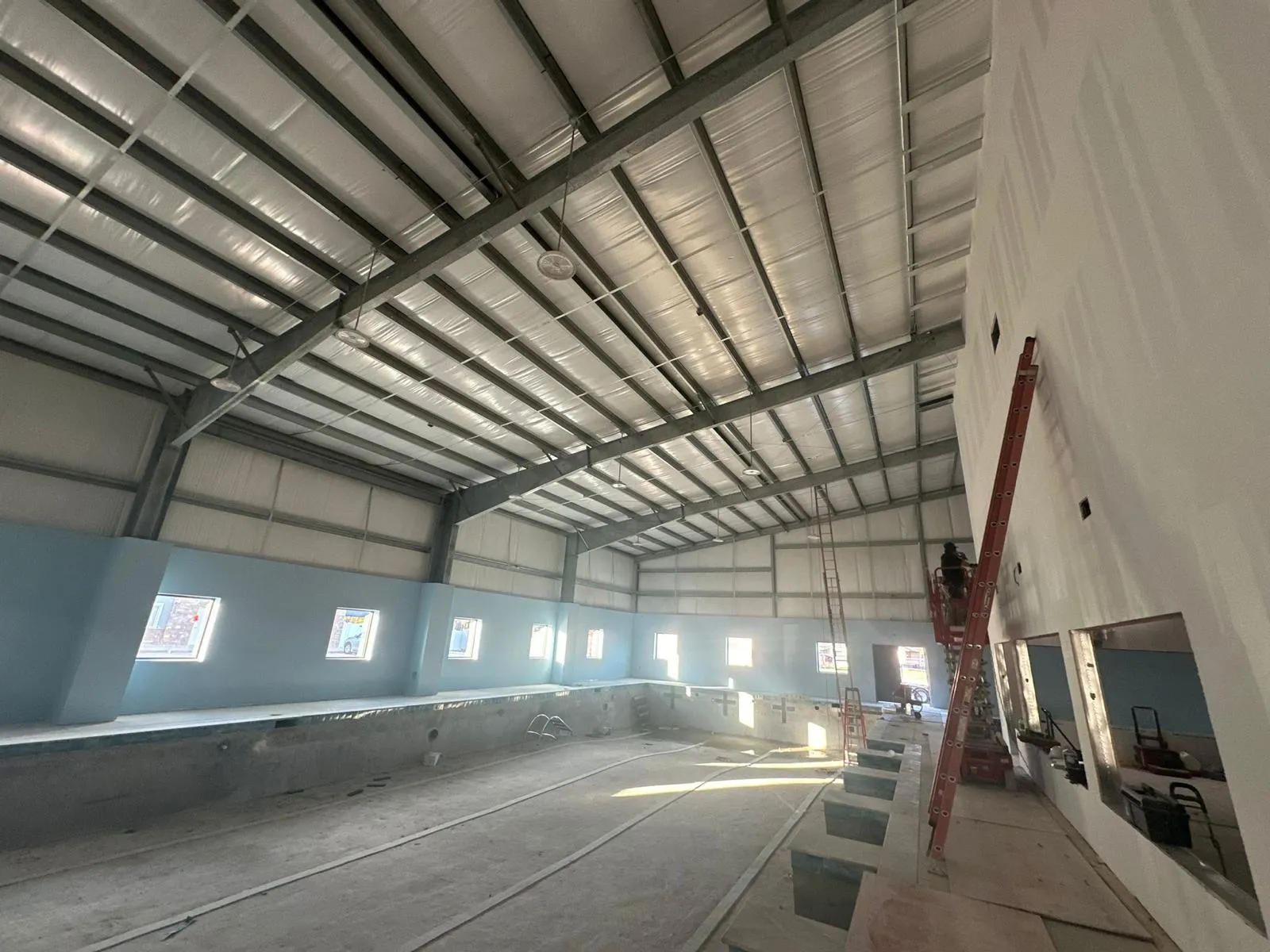 DG technician on a scissor lift wiring a large commercial building