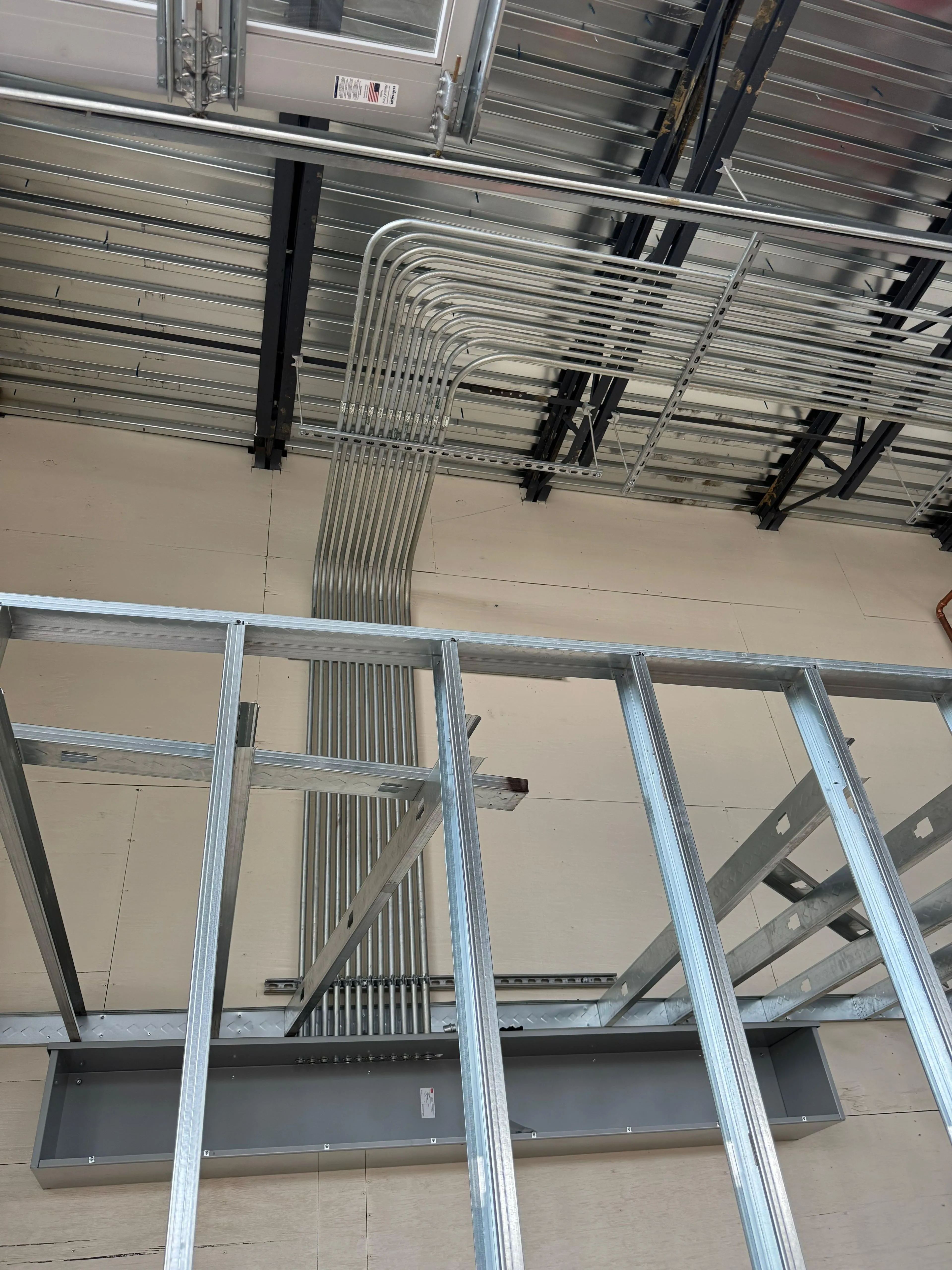Neatly bent parallel EMT conduit runs in a commercial ceiling