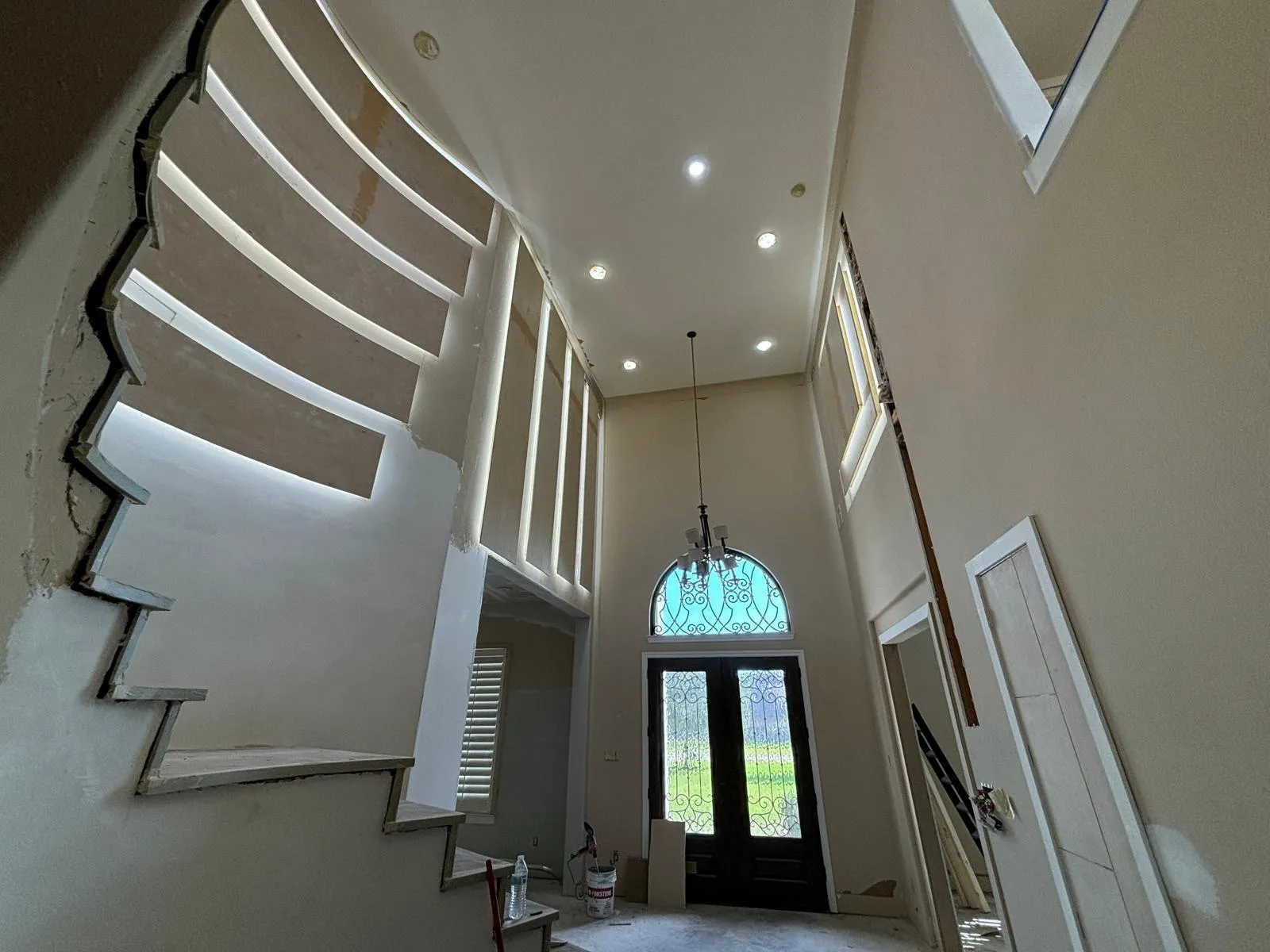Grand entry remodel with arched door, recessed lights and LED staircase wall