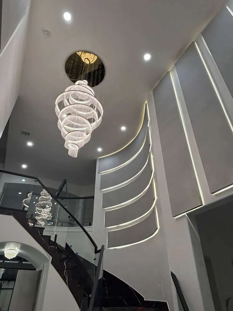 Crystal chandelier and LED accent walls in a finished luxury foyer
