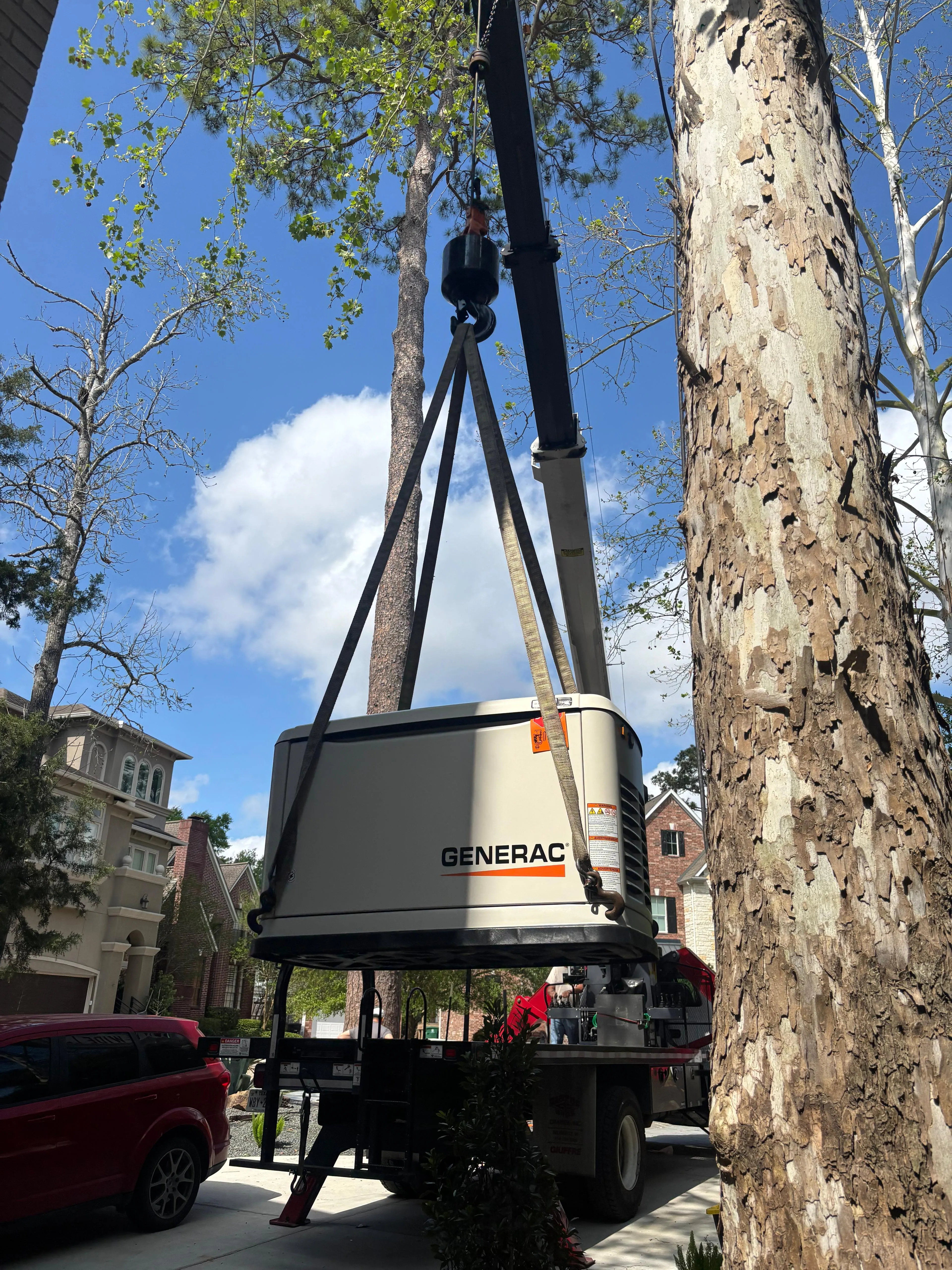 Crane lifting a Generac generator during residential delivery